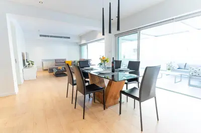 a dining room with a glass table and chairs at Deluxe Downtown with spacious balcony in Nicosia