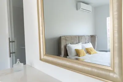 a mirror reflecting a bed with two pillows at Deluxe Downtown with spacious balcony in Nicosia
