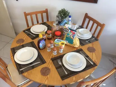 a wooden table with plates and food on it at Guest House in Larnaka