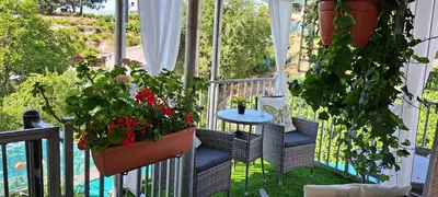 a balcony with plants and a table on it at Kyperounta Troodos mountain house in Limassol