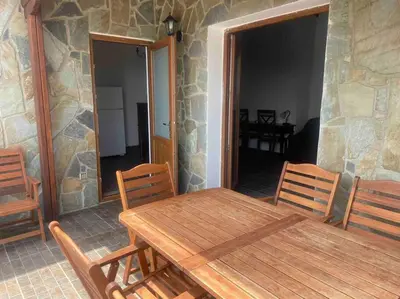 a wooden table and chairs in a room with a stone wall at Mountain View! Cosy life in Nicosia