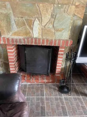 a brick fireplace with a stone wall at Mountain View! Cosy life in Nicosia