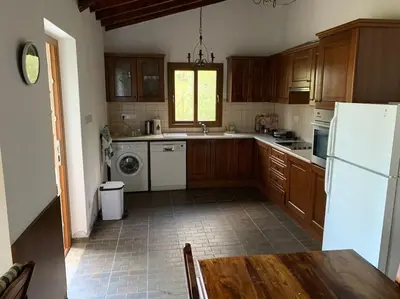 a kitchen with wooden cabinets and a white refrigerator at Mountain View! Cosy life in Nicosia