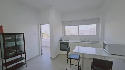 a kitchen with a table and chairs and a microwave at STAY City Life Apartment II in Nicosia