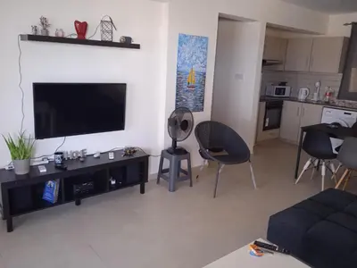 a living room with a flat screen tv on a wall at Xylophagou Rest and Relax 4 Top floor Big Balcony 1 bedroom apartment in Xylophaghou