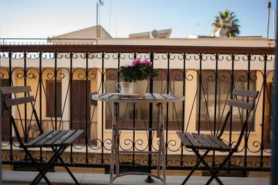 a table with two chairs and flowers on a balcony at Operetta House in Larnaka
