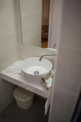 a bathroom with a white sink and a mirror at Operetta House in Larnaka