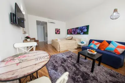 a living room with a blue couch and a table at Operetta House in Larnaka