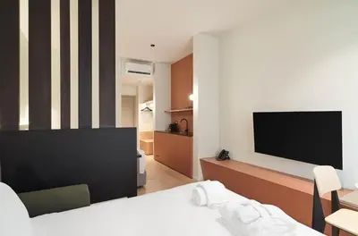 a hotel room with a bed and a flat screen tv at Alinea Diono Historic Center in Limassol