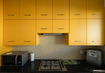 a kitchen with yellow cabinets and a microwave at Maestro Sunrise View in Larnaka