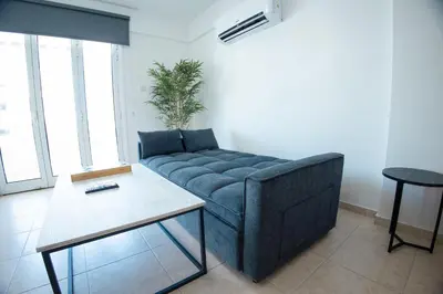 a living room with a couch and a table at Maestro Sunrise View in Larnaka