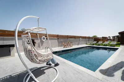 a person sitting in a swing by a swimming pool at Ktima To Alliotiko - Lofou 1 in Lofou