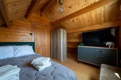 a bedroom with a bed and a flat screen tv at Ktima To Alliotiko - Lofou 1 in Lofou
