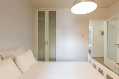 a white bedroom with a bed and a mirror at Agia Napa three bedroom modern flat in Ayia Napa