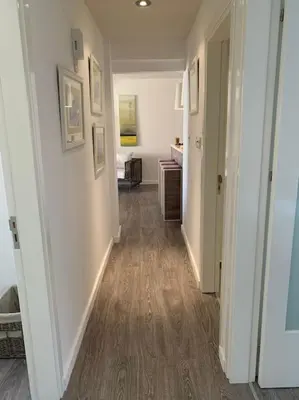 a hallway of a room with white walls and wood floors at Agia Napa three bedroom modern flat in Ayia Napa