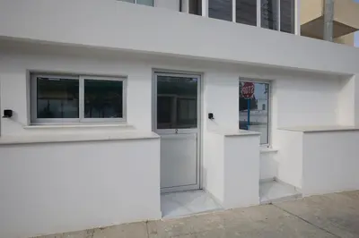 a white building with two windows and a door at Gold Emerging Villas Ltd Apart 1 in Ayia Napa