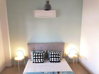 a bedroom with a bed with two tables and two lamps at Yippee! at Ermou Square Amazing Location View in Larnaka