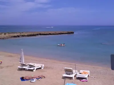 a beach with chairs and a group of people on it at Ivory Suite at Polyxenia - Tourism licence 03125 in Protaras