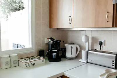 a kitchen counter with a coffee maker and a window at Leah's Deluxe Villa in Tersephanou
