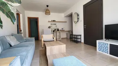 a living room with a blue couch and a tv at Mythical Sands resort - Hana in Paralimni