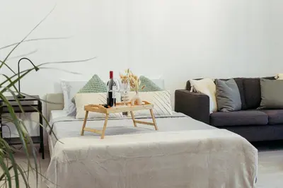 a living room with a couch and a table with wine bottles at Cozy Studio Apt - Tourist Area Collection in Limassol