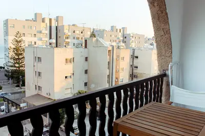 a balcony with a wooden bench and a view of buildings at Cozy Studio Apt - Tourist Area Collection in Limassol