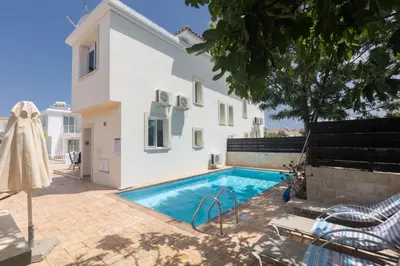 a villa with a swimming pool in front of a house at Protaras Orestiada Villa OV14 in Protaras