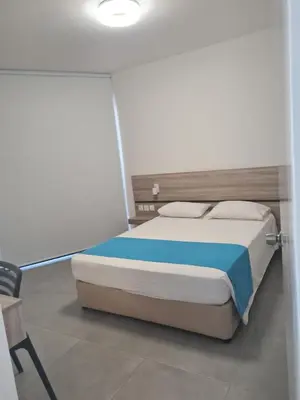 a bedroom with a bed in a white room at Les Palmiers Sunorama Beach Apartments in Larnaka