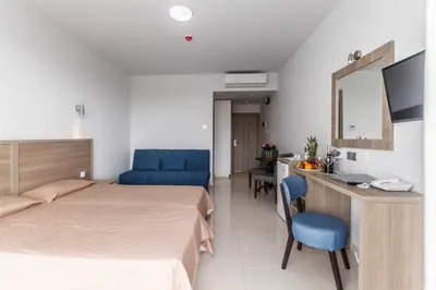 a bedroom with a bed and a desk with a mirror at Bellini Hotel in Ayia Napa