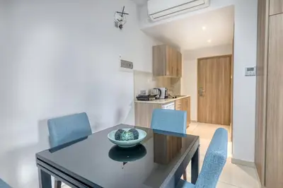 a kitchen and dining room with a table and chairs at Bellini Hotel in Ayia Napa