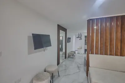 a living room with a television and stools at Gold Emerging Villas Ltd Apart 5 in Ayia Napa