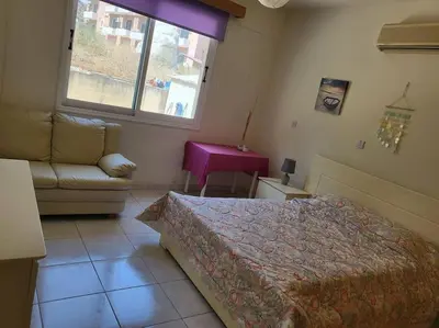 a bedroom with a bed and a couch and a window at Lovely house apartment 2 bedrooms wiht nice view in Voroklini