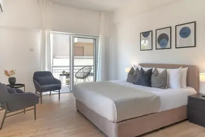 a bedroom with a large bed and a balcony at Phaedrus Living City Breeze Residences Urbanity in Larnaka