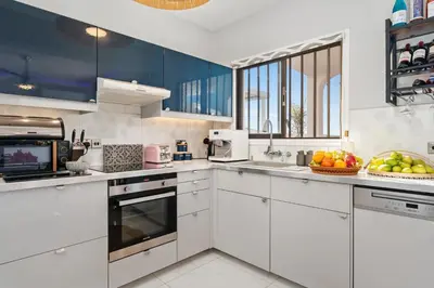 a kitchen with white cabinets and a bowl of fruit at Ayia Napa Villa Jasmine Sirens Beach Dom na Cyprze in Ayia Napa