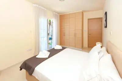 a bedroom with a white bed with two towels on it at Villa Aurora - 100m from Pernera Beach in Protaras