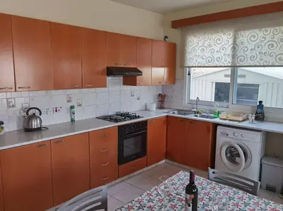 a kitchen with wooden cabinets and a stove top oven at Lovely house apartment Oroklini in Voroklini