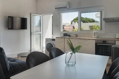 a kitchen with a table with a vase on it at Phaedrus Living City Breeze Residences Grace in Larnaka