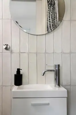a white bathroom with a sink and a mirror at Amazing Two Bedroom Apartment in Larnaka