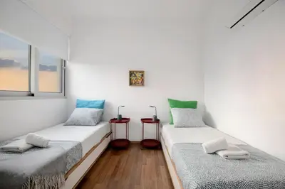 two twin beds in a room with two windows at Amazing Two Bedroom Apartment in Larnaka