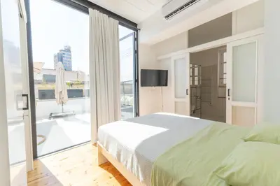 a bedroom with a bed and a large window at 1924 Gemini House Jacuzzi, Garden, Rooftop in Nicosia
