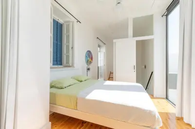 a white bedroom with a large bed and windows at 1924 Gemini House Jacuzzi, Garden, Rooftop in Nicosia