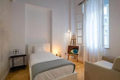 a bedroom with a bed and a couch and a window at 1924 Gemini House Jacuzzi, Garden, Rooftop in Nicosia