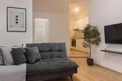 a living room with a couch and a flat screen tv at Phaedrus Living City Breeze Residences Finesse in Larnaka