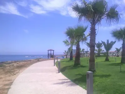 a sidewalk with palm trees on the beach at Maison Diana - Tourism license 6990 in Protaras