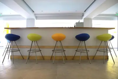 four colorful bar stools in front of a counter at Sea CleoNapa Hotel in Ayia Napa
