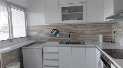 a white kitchen with a sink and a window at ideal famille panoramic view lac salé in Larnaka