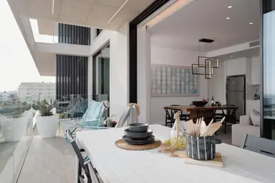 a kitchen with a white table with dishes on it at Protaras Eden Seaside Suite in Protaras