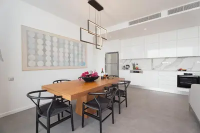 a kitchen and dining room with a wooden table and chairs at Protaras Eden Seaside Suite in Protaras