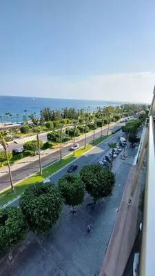 a view of a street with trees and the ocean at Limassol Molos Hawaii Royal - Front-line 2 bedroom in Limassol
