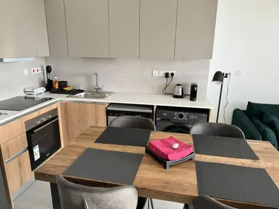 a kitchen with a wooden table with chairs and a sink at Limassol Beautiful Apartment in Limassol